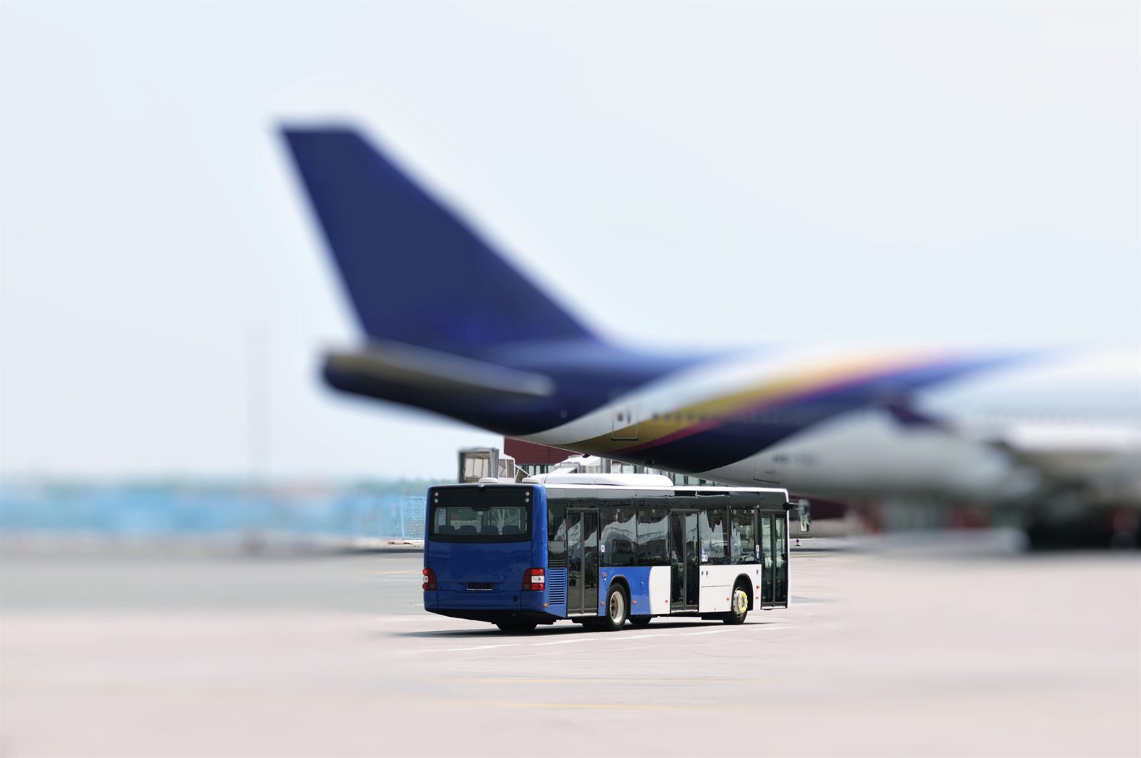 Passenger jet parked on an airport apron with a bus waiting alongside