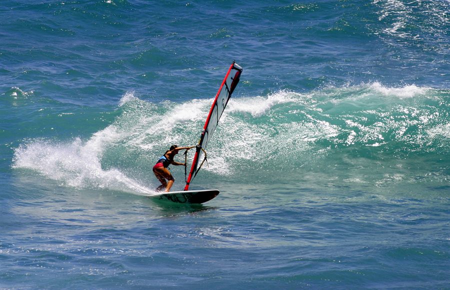 Windsurfer carving through a large breaking wave