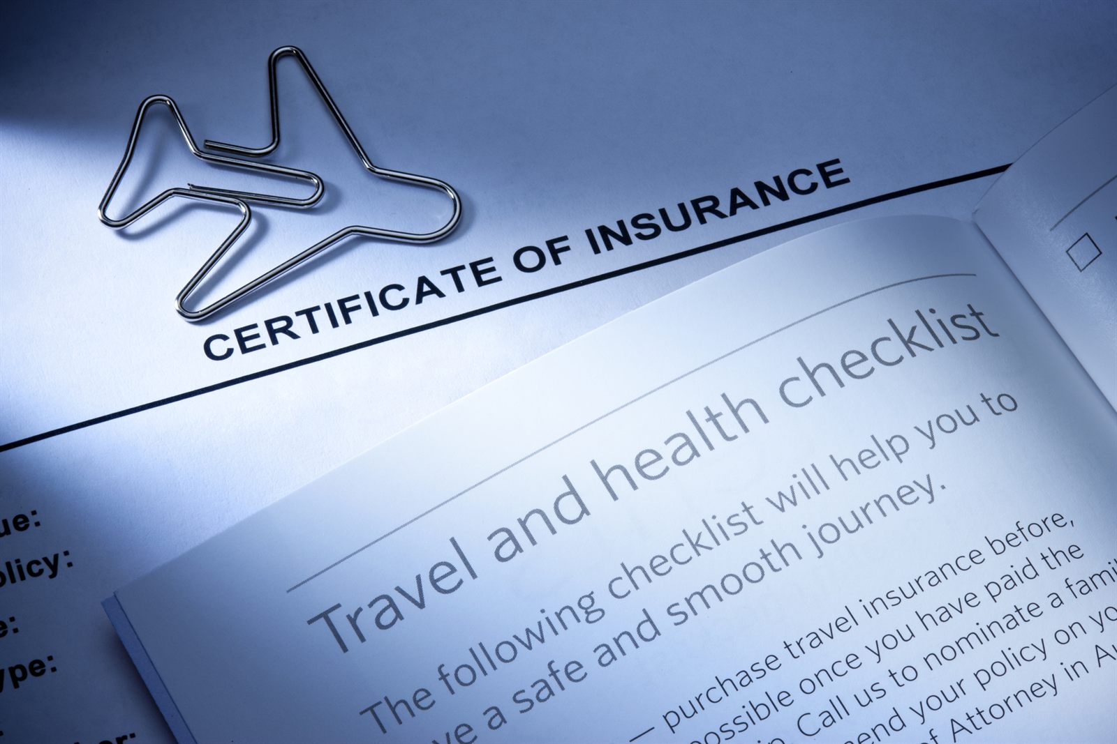 Close-up of a certificate of insurance and a travel and health checklist